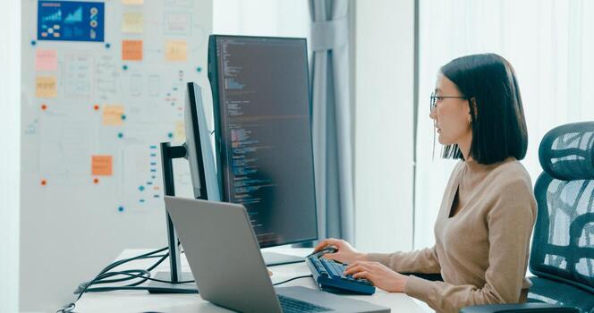 Young Asia female freelance eyeglasses typing write prompt AI bot IT app smart program nomad, game, terminal with coding, user interface, designer, big data center on desktop computer photo