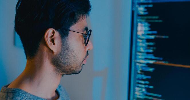 Closeup young adult Asia male typing write prompt AI bot IT app smart program nomad, game, terminal with coding language, designer, big data center on desktop computer in night office. photo