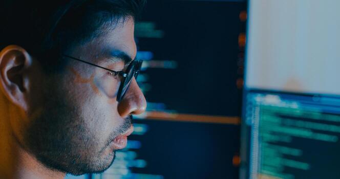 Closeup young adult Asia male write prompt AI bot IT app smart program nomad, game, terminal with coding language, designer, big data center on desktop computer in night office. photo