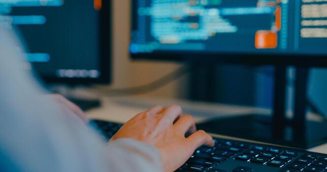 Closeup adult Asia female freelance typing write prompt AI bot IT app program nomad, game, terminal with coding language, designer, big data center on desktop computer in night office. photo