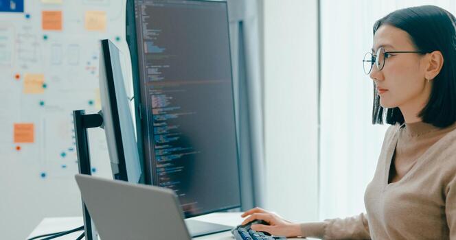 Young Asia female freelance write prompt AI IT app smart program nomad, game, terminal with coding, user interface, designer, big data center on desktop computer. photo