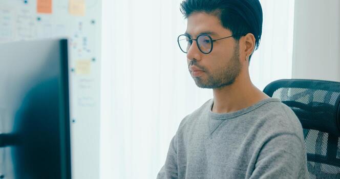 Young adult Asia male freelance typing write prompt AI bot IT app smart program nomad, game, terminal with coding, user interface, data center on desktop computer photo