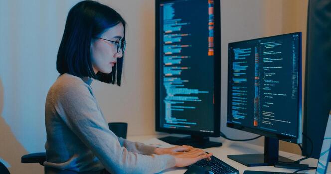 Young Asia female freelance typing write prompt AI bot IT app smart program nomad, game, terminal with coding language, designer, big data center on desktop computer in night office. photo