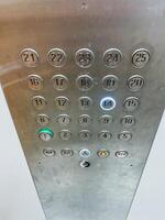 This image showcases a closeup view of elevator buttons, prominently displaying the number 21 at the top. The buttons are made of silver material, enhancing their modern appearance photo