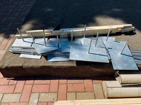 A collection of various metal fragments can be seen scattered across a durable brick sidewalk, creating an interesting contrast between the materials and the surface beneath them photo