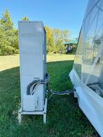Nestled in a picturesque grassy field, a white refrigerator is securely secured to a strong, durable trailer, creating an ideal spot to enjoy the beauty of nature all around it photo