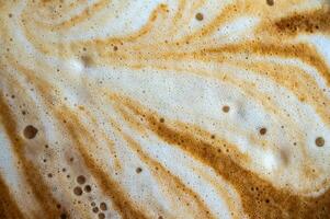 Full frame shot of the surface of hot latte coffee. A latte is a coffee drink made with espresso and steamed milk. photo