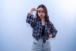 Indonesian Asian woman wearing a checkered shirt with pouting lips and hands in front of her head photo