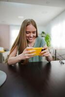Joyful moment of a young woman engaging with a phone in a bright space photo