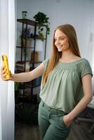 Smiling woman takes a selfie in a cozy indoor setting with plants photo
