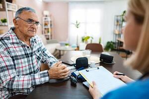 Senior gentleman discusses health concerns with doctor photo