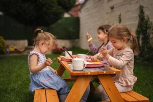 Children enjoy a joyful meal together in a vibrant garden setting photo