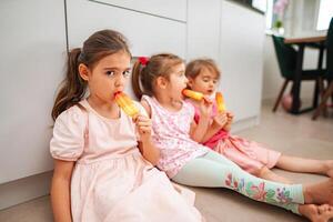 Sisters enjoying colorful popsicles on a warm afternoon photo