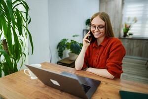 Smiling professional engaged in a call while working from home photo