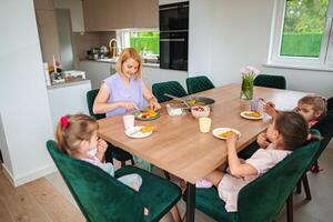 Mother shares a vibrant meal with her children at home photo
