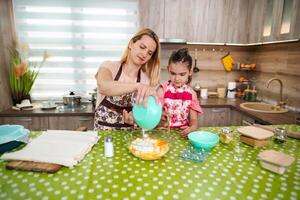 Mother and daughter baking together in a bright kitchen photo