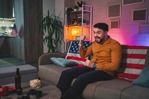 Excitement fills the room as a man celebrates during a game night with friends at home photo