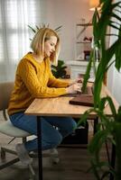 Focused professional in cozy home office working on laptop during a bright afternoon photo