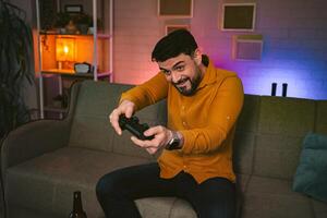 Excitement fills the room as a man immerses himself in an intense game session during a cozy evening at home photo
