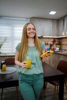 Happy woman enjoying a refreshing drink in a cozy kitchen photo