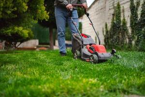 Mowing the lush green lawn on a sunny afternoon in a charming backyard garden setting photo