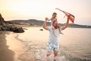 Family enjoys a colorful day flying a kite by the serene beach waters photo