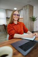 Focused young woman jotting down ideas in a cozy workspace photo