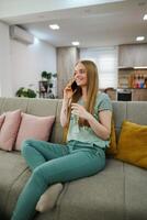 Woman enjoying a relaxing phone call in a cozy living room photo