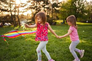 Joyful children flying a colorful kite in a sunny park photo