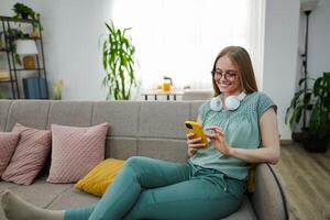 Relaxing at home with a smartphone and headphones in cozy atmosphere photo