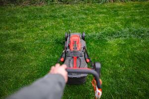Mowing the lush green lawn on a bright afternoon in early spring photo