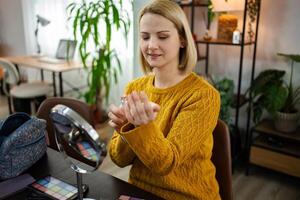 Woman applying perfume while preparing for a cozy day at home in a welcoming and stylish living space filled with greenery photo