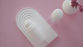 white deodorant bottle on arched tray with pink background video