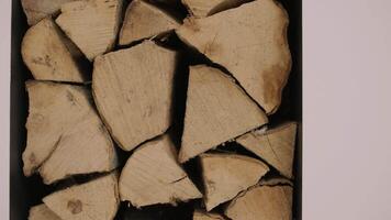 Stacked firewood in a modern black alcove creates a rustic yet elegant feature in a luxury home's fireplace setting, blending functionality with design. video