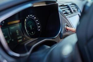 Hand pressing car engine start button inside modern vehicle photo