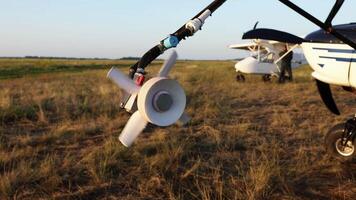 lose-up of spinning propeller nozzle on agricultural aircraft spraying system, golden field at sunset, blurred pilot and airplane in background, crop aviation, farming, agrotechnology video