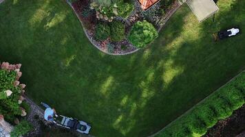 Two Landscapers Work on a Residential Lawn in a Well-Maintained Garden video
