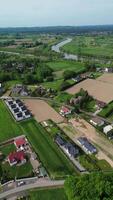 aéreo ver de un devanado río rodeado por lozano verde campos y arboles el paisaje caracteristicas un mezcla de tierras de cultivo y natural vegetación. video