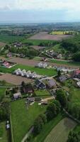 dar visie van een landelijk landschap met velden, een rivier, klein huizen. groen heuvels in de achtergrond onder een Doorzichtig lucht. video
