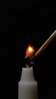 encendido un blanco vela utilizando un de madera fósforo en un oscurecido ambiente, capturar un momento de iluminación y atmósfera creación. video