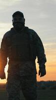 Two soldiers walk shoulder to shoulder at dusk. United by purpose, they return from patrol as the sunset paints the sky behind them. video