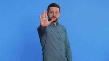 sluta, tillräckligt. medelålders man säga Nej håll handflatan vikta korsade händer i Avsluta gest, varning av Avsluta, förbjuden tillgång, minskande kommunikation, kropp språk fara. kille på blå bakgrund video