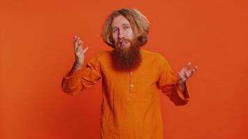 Vad. Varför. arg caucasian man höjning händer i indignerad uttryck, be anledning av fel, demonstrera misstro irritation förbi problem. rödhårig ung kille isolerat på orange studio bakgrund video