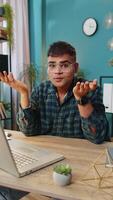 I don't know what to say. Confused Indian man feeling embarrassed about ambiguous question, having doubts, no idea, being clueless and uncertain. Hispanic guy at home office table workplace. Vertical video