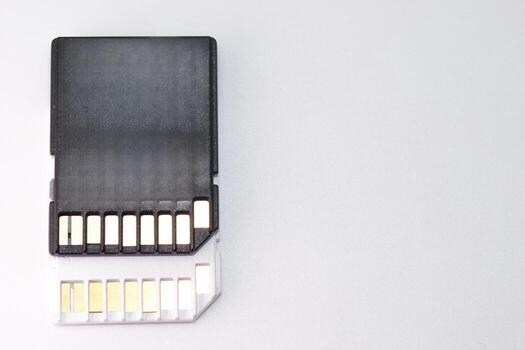 Memory card placed against a light surface highlighting its design and connection pins for data storage photo