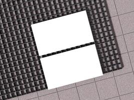White business cards displayed on concrete floor with black gridded surface. photo