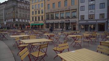 April 10, 2022. Munich. Germany. Empty outdoor cafe at Max-Joseph-Platz, Munich, during the off-season. Cold, grey weather and vacant seating reflect the stillness of a quiet, lifeless square. video