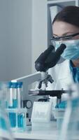 en tillägnad forskare i en labb täcka studier testa prover under en kraftfull mikroskop, highlighting de betydelse av Avancerad forskning i en avancerad labb, exemplifierande framtida innovation och upptäckt video