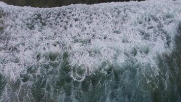 Aerial view of waves crashing on the shoreline, creating a captivating scene of nature video