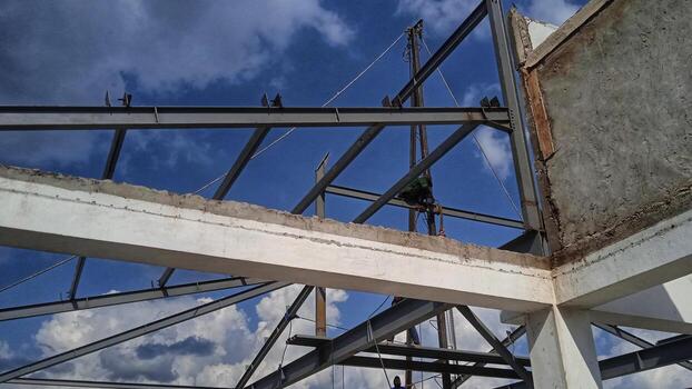 A man is working on a building under a blue sky photo